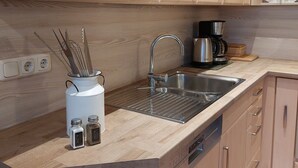Una cucina moderna con mobili in legno, un lavello in acciaio inossidabile e una macchina da caffè.