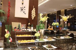 Montaje de bufé con diversos alimentos y elementos decorativos.