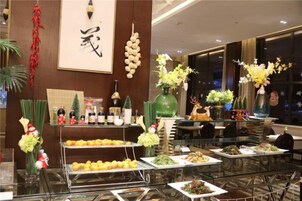 Montaje de bufé con diversos alimentos y elementos decorativos.