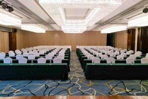 A conference room with rows of tables, each with a white chair and a water bottle. - Timing International Hotel Zhoukou (Zhoukou)