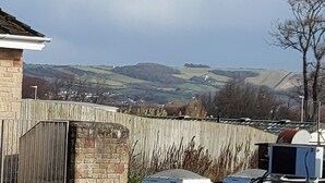 A rural landscape with a stone wall, a wooden fence, and a view of rolling hills in the distance. - 1st Floor Hillview 2 Bedroomed Central Location (Burnham-on-Sea)
