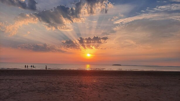 A beach with the sun setting over the horizon, casting rays of light through clouds. - 1st Floor Hillview 2 Bedroomed Central Location (Burnham-on-Sea)