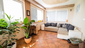 Una sala de estar con un sofá, una mesa de centro y plantas en macetas.
