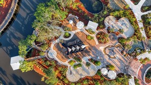 An aerial view of a landscaped area with pathways, seating areas, and a central water feature.