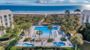Un complexe hôtelier doté d’une piscine centrale, de plusieurs espaces de détente et offrant une vue sur la plage.