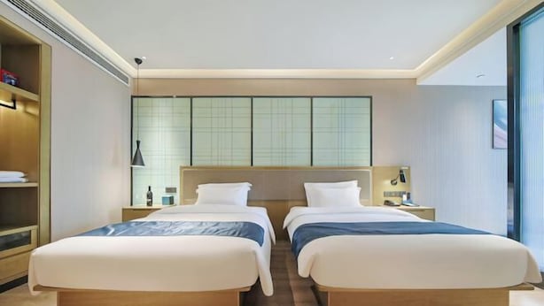 A hotel room with two beds, a large window with a view, and a traditional Japanese-style wall panel. - Shangyi Hotel (Qianxi High speed Railway Station Branch) (Qianxi)