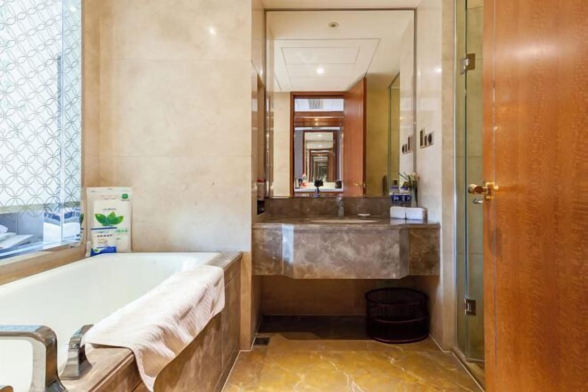 A bathroom with a bathtub, a sink, and a mirror.