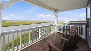 A covered porch with a view of a river and marshland. - Blue Pearl #106-Soundfront with Private Dock, Kayaks & Walkable Beach Access! (North Topsail Beach)