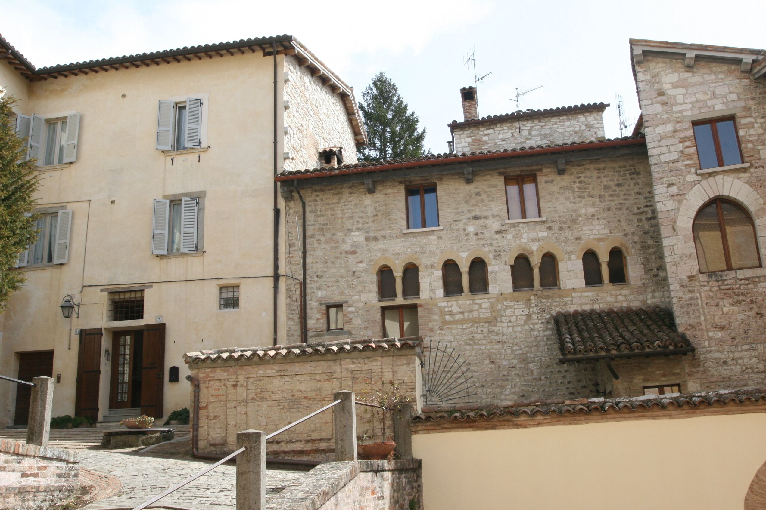 A traditional stone building with multiple windows and a central entrance.
