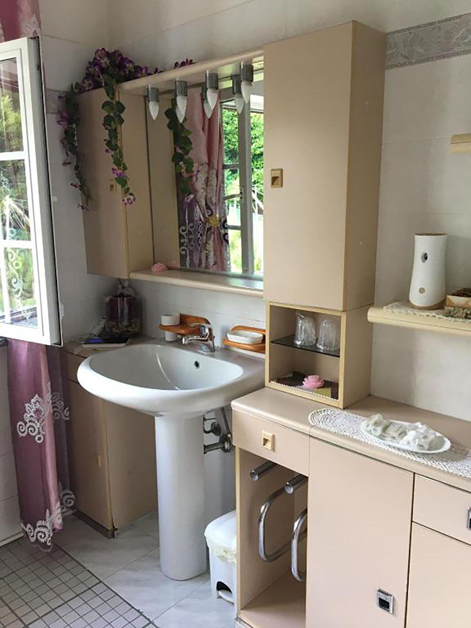 A bathroom with a sink, mirror, and storage cabinets.