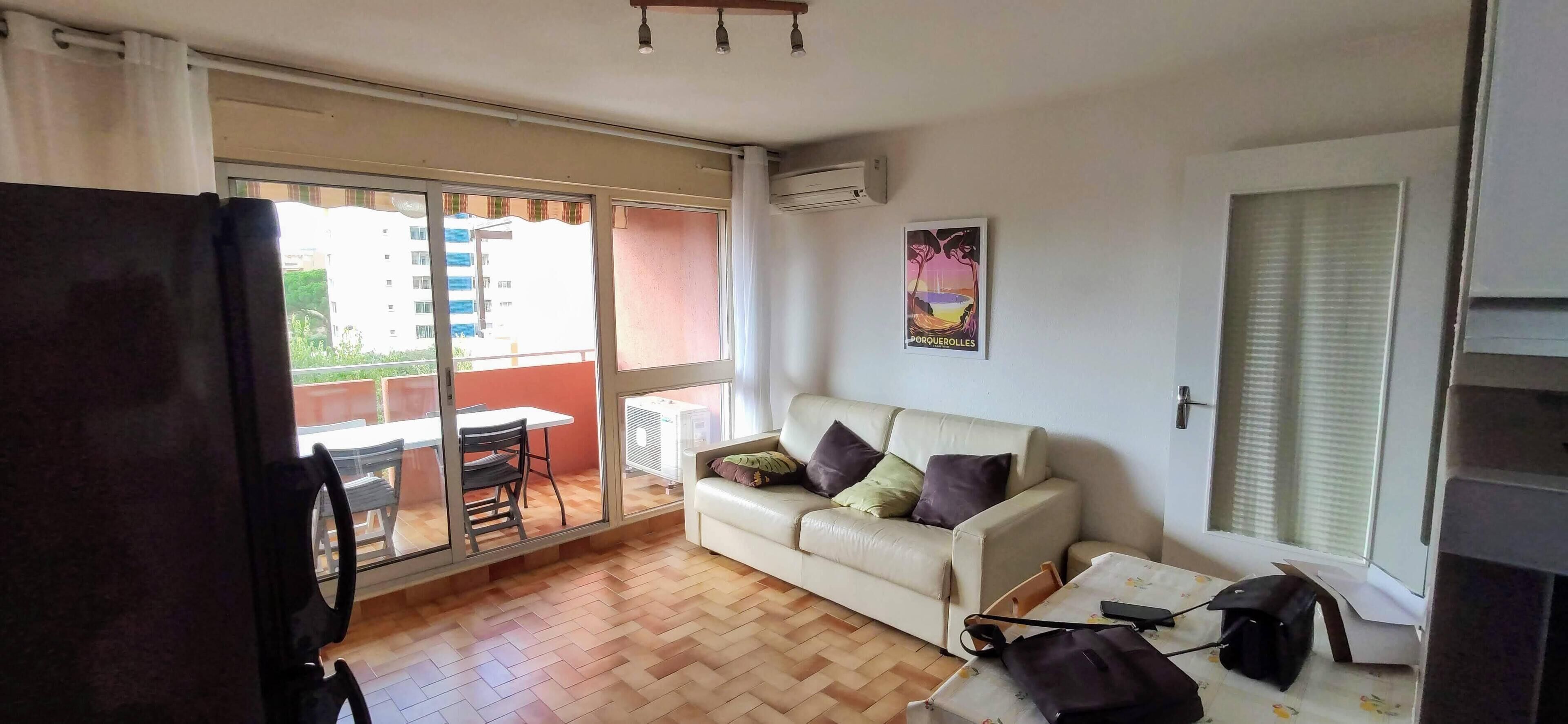 Una sala de estar con sofá, una mesa y puerta corrediza de vidrio que da a un espacio exterior.
