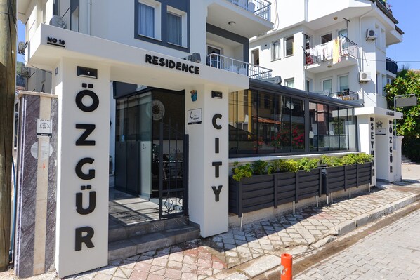 Rakennuksessa on kyltti, jossa lukee ”RESIDENCE CITY” ja ”OZGÜR”.