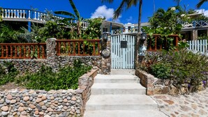 A stone staircase leading to a gated entrance with a sign reading "Villa Oranise."