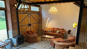 Una sala de estar acogedora con chimenea, muebles de madera y una araña.