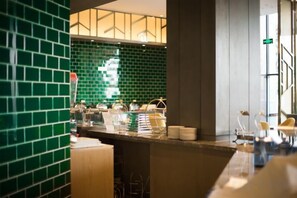 A hotel lobby with a green-tiled wall, a reception desk, and a seating area. - Rongzhou Hotel (Rong County)