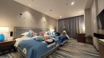 Una habitación de hotel con una cama grande, un escritorio y un televisor.
