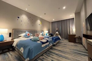 Una habitación de hotel con una cama grande, un escritorio y un televisor.