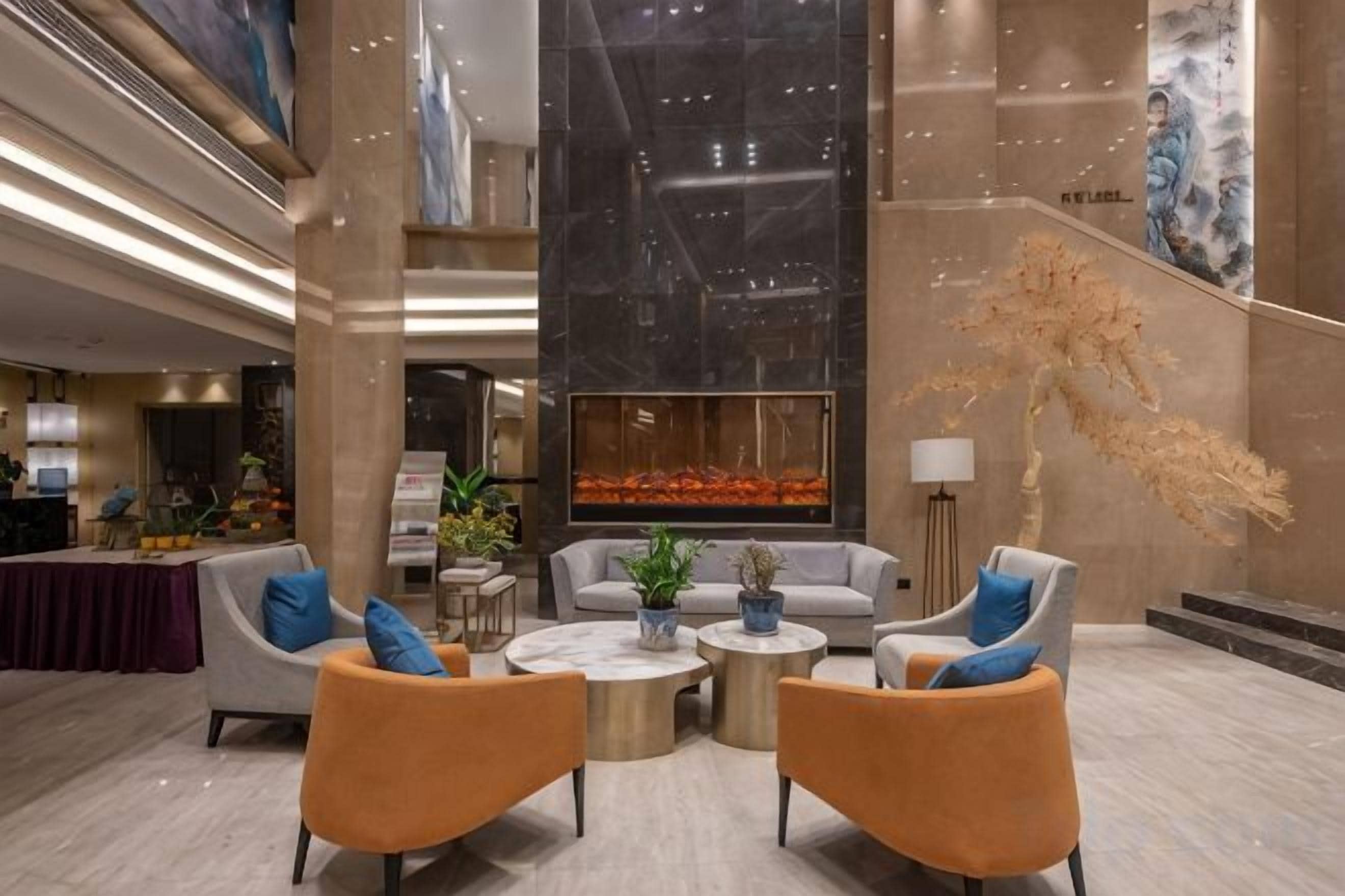 Um lobby moderno com balcão de recepção, área de estar e uma grande escultura abstrata.