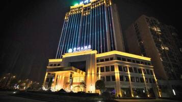 A multi-story hotel with illuminated signage and a prominent entrance.