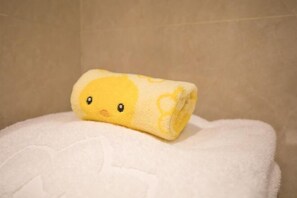 A rolled-up towel with a yellow duck pattern on a white towel. - Rongzhou Hotel (Rong County)