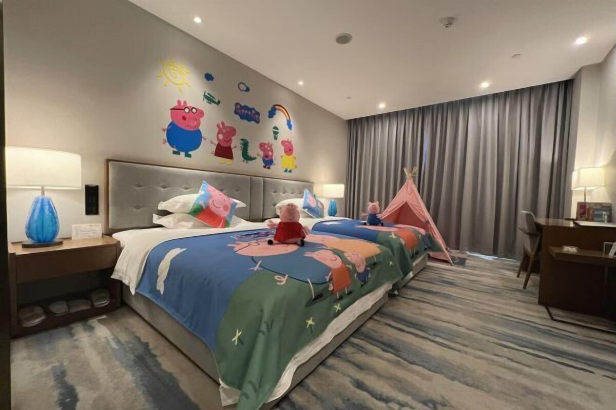 Une chambre d’hôtel avec un grand lit, un bureau, une chaise et une fenêtre avec des rideaux.