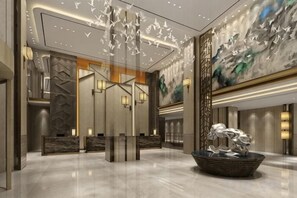 A modern lobby with a reception desk, a decorative wall with abstract patterns, and a large painting. - Rongzhou Hotel (Rong County)