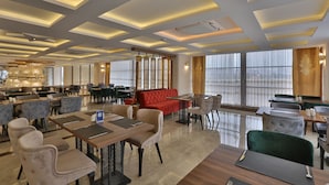 A spacious hotel lobby with multiple seating areas, including a red sofa and various chairs. - Anemon Mardin Otel (Kiziltepe)