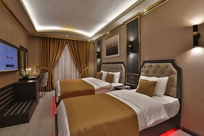 A hotel room with two beds, a desk, a TV, and a large window with curtains. - Anemon Mardin Otel (Kiziltepe)