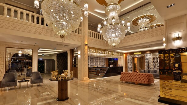 A spacious lobby with a high ceiling, chandeliers, a seating area, and a reception desk. - Anemon Mardin Otel (Kiziltepe)