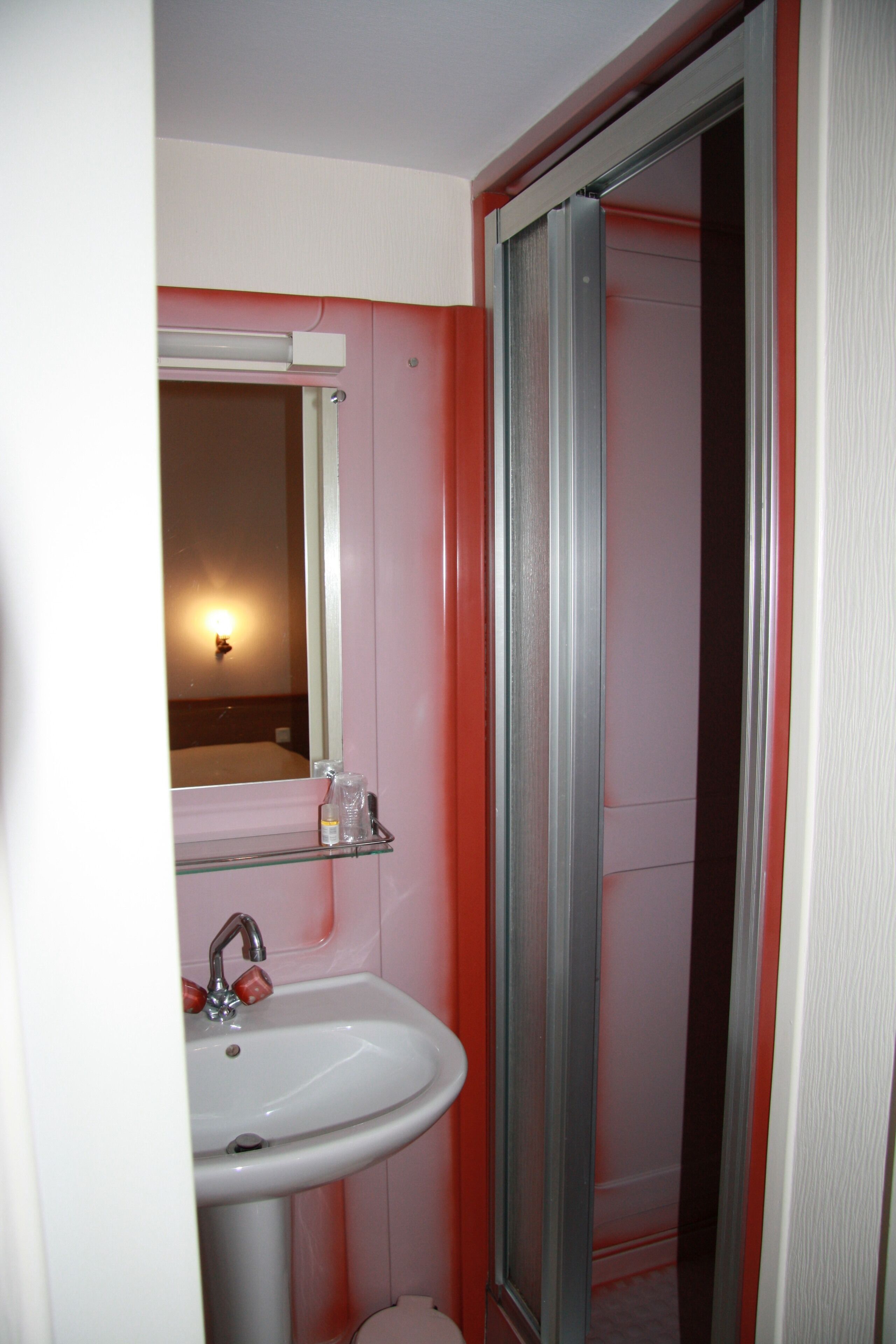 Une salle de bain avec un lavabo, un miroir et une douche.