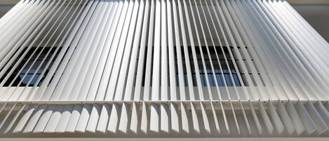 A modern building with a distinctive slatted facade and a sign indicating it is part of the Alinea Urban hotel.