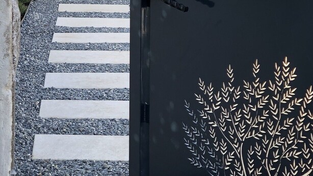 Une porte ornée de l’inscription « Mas d’Arthu » et d’un motif décoratif représentant un arbre.