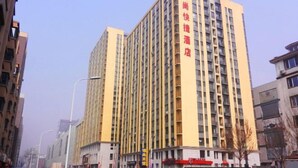 Un edificio alto de varios pisos con un letrero rojo llamativo en la fachada.