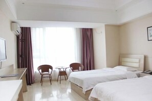 A hotel room with two beds, a desk, a chair, a small table, and a TV. - Jinshang Express Motel (Shenyang)