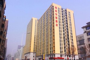 A multi-story hotel with a prominent vertical sign, a flat facade, and a uniform window pattern. - Jinshang Express Motel (Shenyang)