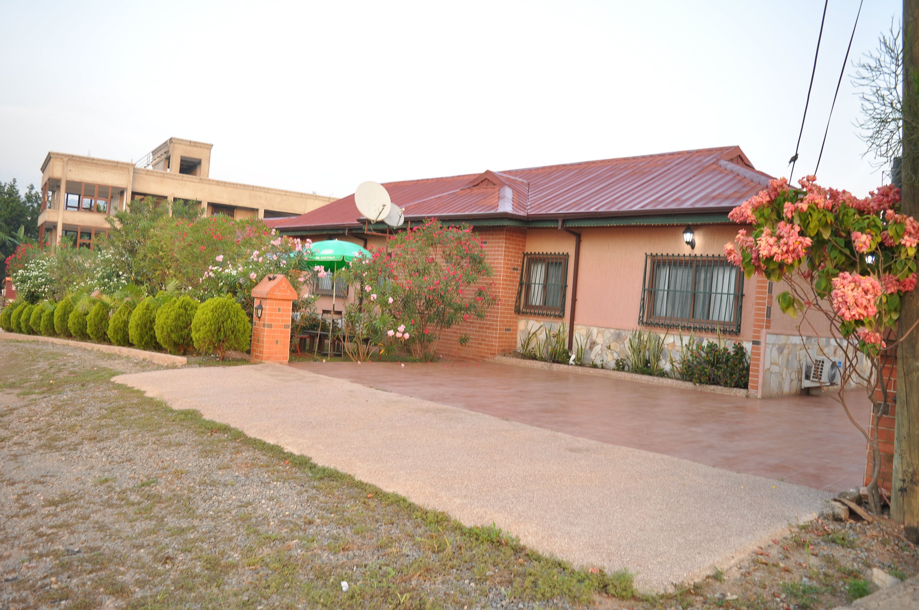 A residential building with a brick facade, a red roof, and a satellite dish.