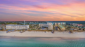 Ein Hotel an der Küste mit mehreren Gebäuden, einem Strand und freiem Blick auf den Ozean.