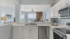 A modern kitchen with white cabinets, a stainless steel dishwasher, and an oven. - Destin West Gulfside 301 ~ True Beachfront Luxury ~ Beautiful Views! (Fort Walton Beach)