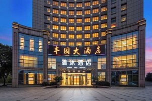 A hotel with a modern facade, multiple floors, and illuminated signage.