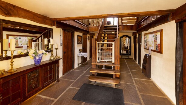 A wooden staircase leading to a second floor, flanked by wooden paneling and a black doormat. - Authentic 100 year old barn, indoor pool (Gouttières)