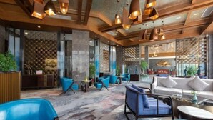 Ein modernes Interieur mit blau-weißer Sitzmöbeln, Holzbalken und Pendelleuchten.