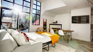 Een moderne slaapkamer met een groot bed, een bureau en een televisie.