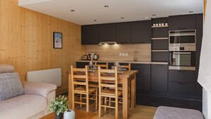 A compact living space with a kitchenette, a dining area, and a seating area.