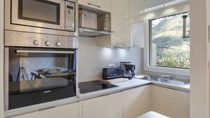 Una cocina moderna con horno empotrado, microondas y tostadora.