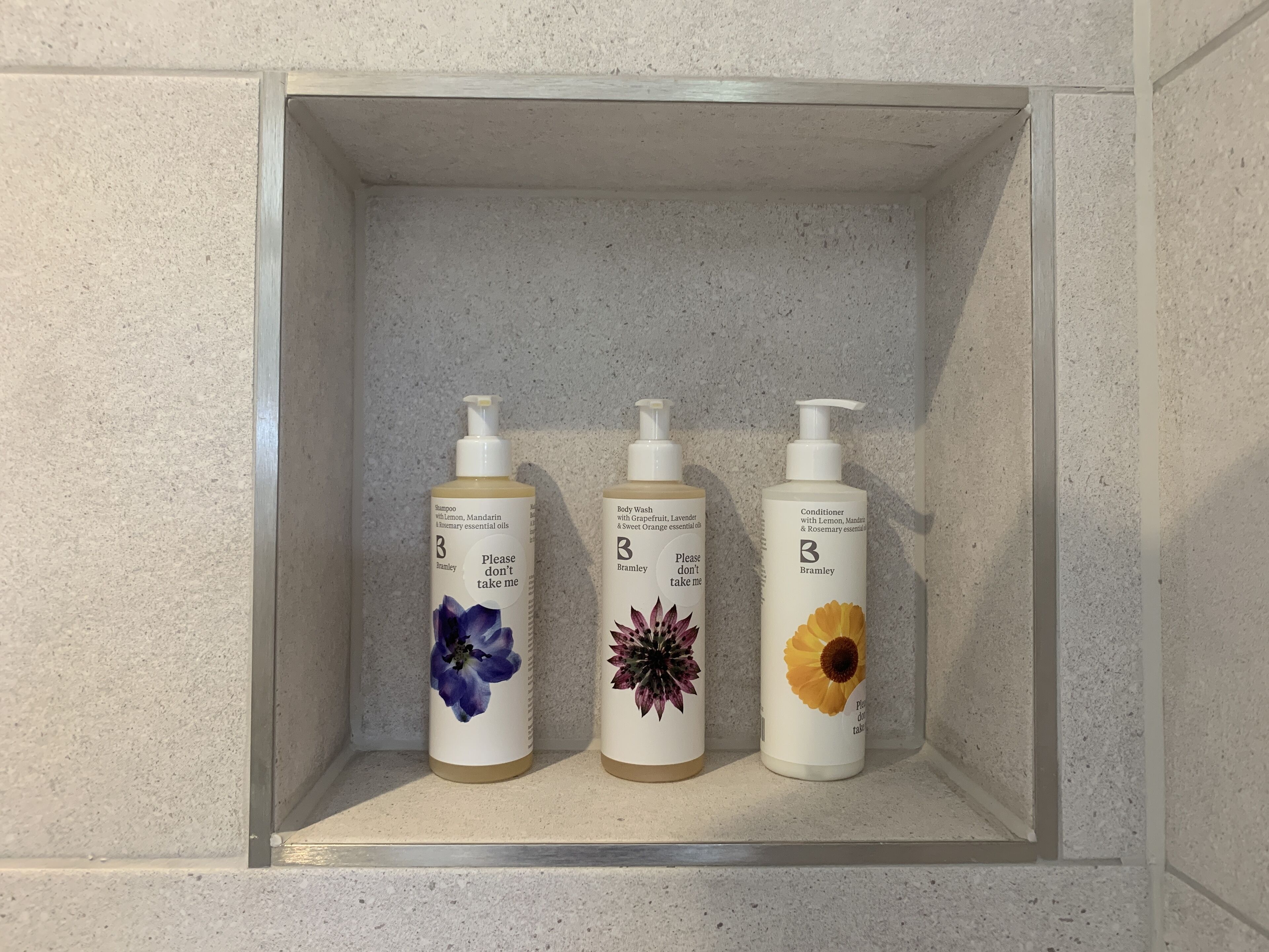 Three bottles of skincare products on a shelf.
