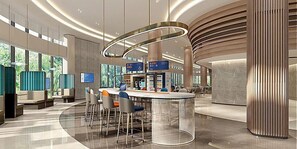 Relax in our stylish lobby, featuring a central bar area with comfortable seating and a unique curved ceiling.