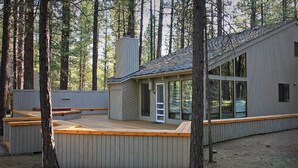 A modern cabin with a deck, large windows, and a chimney. - Cozy 3 bed, 2 bath, Pet Friendly home. HOT TUB! (Black Butte Ranch)