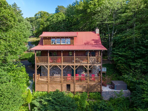 A two-story log cabin with a red roof, multiple balconies, and a stone foundation. - Whispering Ridge Retreat - 7 mins. to downtown Boone, hot tub, great views, pool table! (Boone)