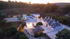 Une villa moderne dotée d’une piscine, de plusieurs bâtiments et surplombant un paysage montagneux.