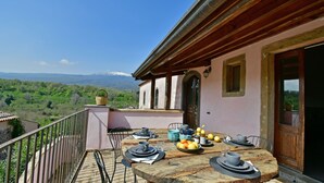 Ein Balkon mit Frühstückstisch, einem Korbwicker-Korb und Blick auf die Berge.